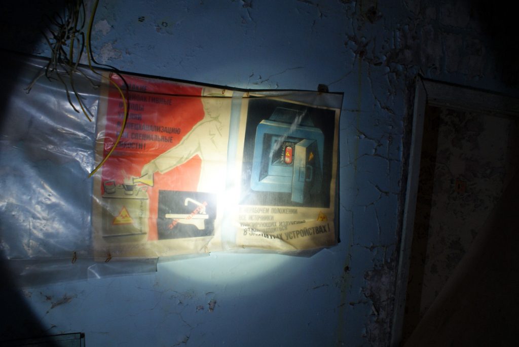 Plakat ostrzegawczy na jednym z korytarzy w budynku administracyjnym. / Fot. Tomasz Róg